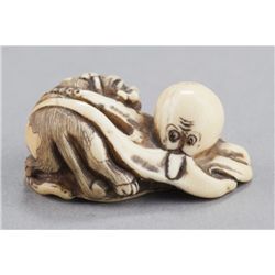 An ivory netsuke of an octopus and piebald cat.