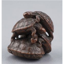 A wood netsuke of a turtle group.