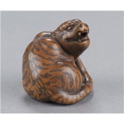 A wood netsuke of a tiger.