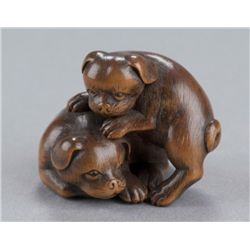 A wood netsuke of two puppies.