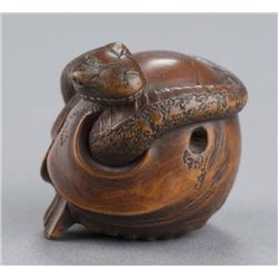 A wood netsuke of a snake and skull.