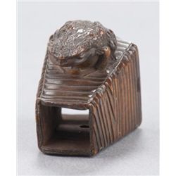 A wood netsuke of a frog.