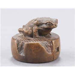 A wood netsuke of a toad.