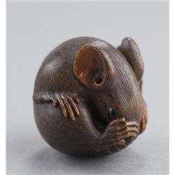 A wood netsuke of a coiled rat.