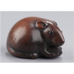 A wood netsuke of a rat.