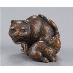 A wood netsuke of a tigress and cub.