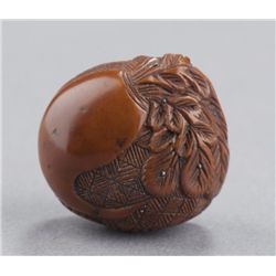 A nut netsuke of a daikon and rats.