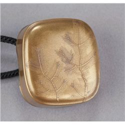 A gold lacquer manju of pine sprays.