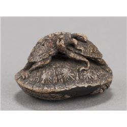 A pottery and lacquer netsuke of three turtles.