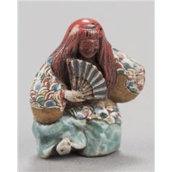 A pottery and lacquer netsuke of a Shojo dancer.