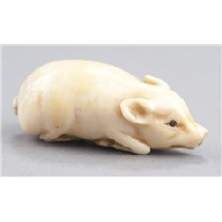 A marine ivory netsuke of a piglet.