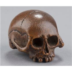 A bamboo netsuke of a skull.