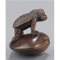 A wood netsuke of Kappa on a clamshell.