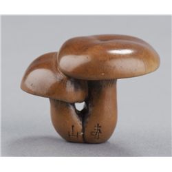A wood netsuke of mushrooms.