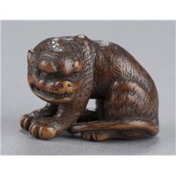 A wood netsuke of a tigress