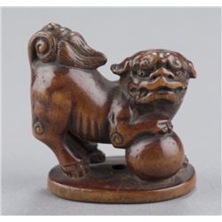 A wood netsuke of shishi.
