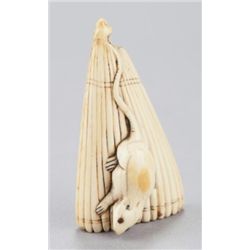 An ivory netsuke of a mouse on a kasa.