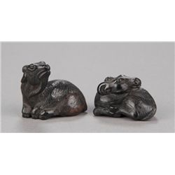 A group of two wood netsuke of goats.