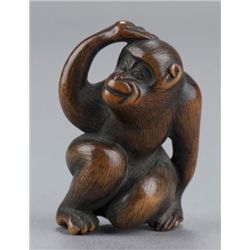 Wood netsuke of seated monkey.