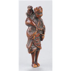 A wood netsuke of a monkey trainer.