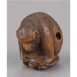 A boxwood netsuke of a monkey atop a tortoise.