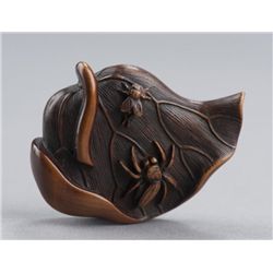 A wood netsuke of a lotus leaf.