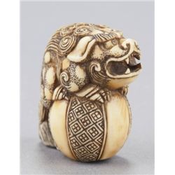 An ivory netsuke of a Shishi.