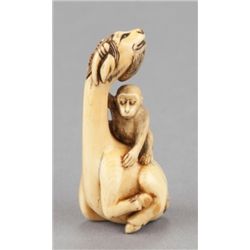 An ivory netsuke of a siniu and monkey.