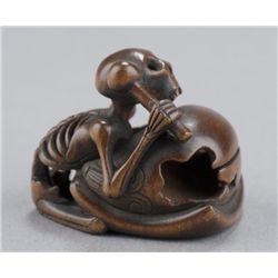 A wood netsuke of a skeleton.