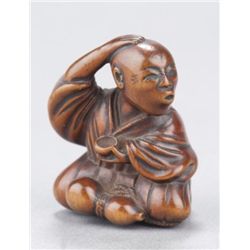 A wood netsuke of a mendicant.