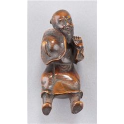 A wood netsuke of a Mongolian man.