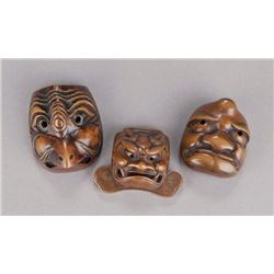 A group of three wood mask netsuke.