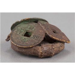 A lacquered wood netsuke of coins.