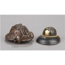 A group of two netsuke of helmets.