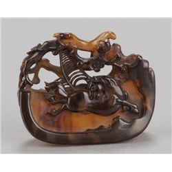 A tortoise-shell netsuke of a horse and spiderweb.