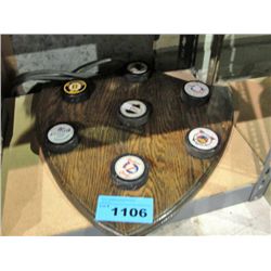 Wooden plaque with assorted hockey team logo pucks