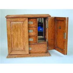A Victorian oak smokers cabinet with two panelled doors and a fitted interior