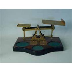 A large set of Victorian/Edwardian postal scales on a mahogany base