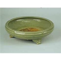 An early Ming celadon bulb bowl with a ringed edge on three mask feet (restored) 27 cm diameter Est.