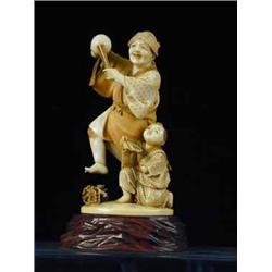 A late l9th/early 20th Century Japanese ivory group of a dancing man and a child with a fan