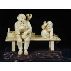 A late l9th/early 20th Century Japanese ivory group of an old man with a pipe seated on a bench