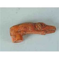 A stained ivory walking stick handle carved in the form of a crouching dog