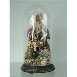 A pedlar doll under glass dome