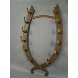 A large oak horseshoe shaped gun rack with hoof rests
