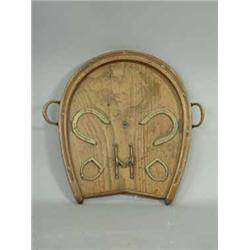 A Victorian oak horseshoe shaped tray with stirrup shaped handles and applied brass horseshoes