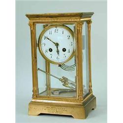 A lacquered brass and four glass panel mantel clock with an enamel dial and a mercury weighted pendu