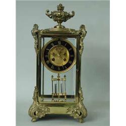 A late 19th century French brass mantel clock having a visible escapement and cast mounts