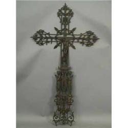 A cast iron crucifix with pierced figures and decoration including Christ on the cross