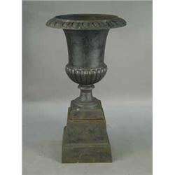 A modern cast iron garden urn and stand of campagna style