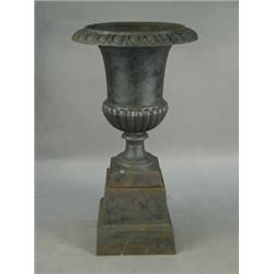 A modern cast iron garden urn and stand of campagna style